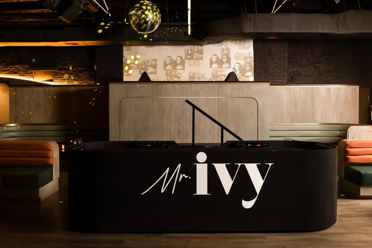 Mr. Ivy DJ booth with disco ball and branded signage — commercial venue by Treacy Brothers